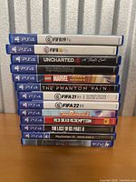 Stack of 11 PS4 game cases with titles visible on spine.