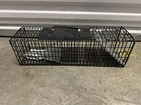 Front side view of cage showing wire mesh construction and metal base