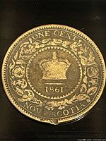 Close-up of the reverse side of the 1861 Nova Scotia bronze one cent coin showing the crown, floral wreath, and inscriptions 'ONE CENT' and 'NOVA SCOTIA'.