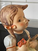 Close-up image of the side of the girl's head showing detailed paintwork on hair and ear, highlighting the detailed painting and condition.