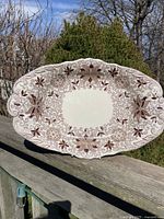 Front view of the large oval ironstone bowl showing the detailed Bow Bells brown floral and leaf pattern on a white background, with embossed edges.