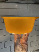 Side view showing the solid tangerine orange color of the bowl with minor surface wear.