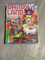 Front of the sealed Candy Land board game box showing colorful candy-themed artwork and Hasbro branding.