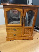 Front view of the vintage wooden jewelry box with glass etched floral doors and two drawers