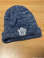 Full view of the blue and white knit beanie with visible folded cuff and embroidered Toronto Maple Leafs logo