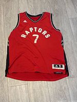 Front full shot of red Toronto Raptors basketball jersey with large number 7 and Adidas branding