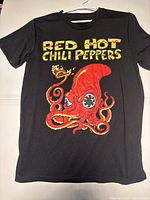 Front view of black Red Hot Chili Peppers T-shirt featuring large red octopus graphic and yellow band text.