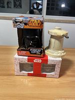 Star Wars Face Off dice game with Darth Vader mask in box, small beige toy tower, and Star Wars set of glasses box
