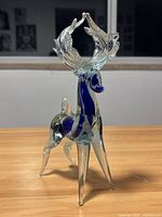 Front angled view of Murano glass deer figurine showing detailed antlers and blue glass accents on body.