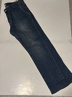 Full view of jeans showing the side profile and overall condition.