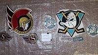 Full lot showing all patches: Ottawa Senators, Anaheim Mighty Ducks, and CCM tags on a textured surface