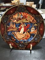 Front of Russian Seasons collectible plate depicting summertime scene with traditional Russian architecture, woman on boat, decorative border.