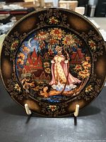 Front view of Russian Seasons Collection decorative plate number 4 depicting Autumn Fantasie scene with detailed artwork of a woman in traditional dress, autumn trees, and village houses.