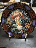 Front view of a decorative porcelain plate with detailed Russian winter scene and ornate border design.