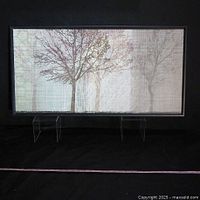 Front view of the large rectangular abstract canvas painting showing tree motif in soft muted colors with layered texture and dark wood frame.