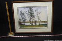 Front view of the framed acrylic painting showing landscape with trees by a river and signature.