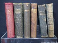 Photo of six vintage books with titles visible on spines including Poems of Tennyson, The Poetical Works of Scott, Longfellow, Tennyson Poems, Poetical Works of Wordsworth and an unknown sixth book with worn spine.