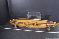 Front view of the Warp Street Tools vintage longboard skateboard showing the wooden deck design and trucks with wheels, measuring 9 inches by 46 inches.