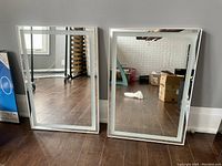 Front view of two rectangular LED bathroom mirrors with integrated light border and touch sensor