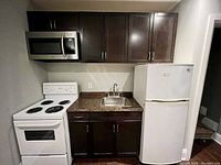 View of the assembled kitchen cabinets with sink installed, including upper and lower cabinets and countertop.