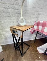 Wood side table with metal frame and power outlet visible from side angle showing power box attached.