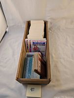 Wooden box packed with long stacks of hockey cards showing some card faces including the top card featuring player Guy Lafleur