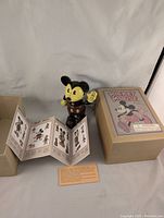 Wind-up tin Mickey Mouse toy standing with original box and unfolded instruction leaflet visible