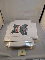 Stack of sealed greeting cards showing a stylized whale/fish motif on top