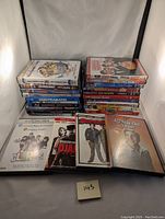Front view of the lot showing stacked DVDs and four DVDs laid out flat: Clerks, Distinguished Gentleman, Superbad, 40 Year Old Virgin.