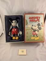 Full view of the Disney Mickey Mouse doll in original box together, box upright with front illustration visible.