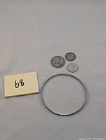 Photo showing the sterling silver bracelet and the three coins together from a distance.