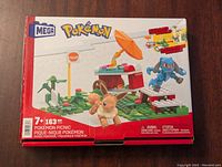 Front of product box showing completed picnic scene with Pokemon figures Eevee and Machop and set details.