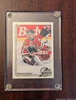 Front view of Dominik Hasek rookie hockey card in Chicago Blackhawks goalie gear, encased in clear plastic holder.