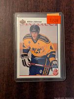 Front of Nicklas Lidstrom rookie card showing him in yellow Swedish jersey, inside plastic sleeve, price sticker $1.50 visible