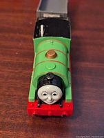 Front view of Percy engine showing face, green body, gold dome and battery compartment under wagon