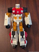 Front view of Silverbolt figure in robot mode showing red chest, white arms and legs, yellow accents, and black hands and feet.