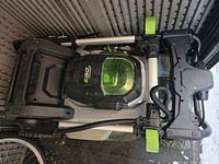 Mower folded with handlebar collapsed, showing side frame and wheels