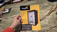 Instruction manual cover showing a photo of the assembled Pro Photo LED Booth by Impact with dimmer lighting.