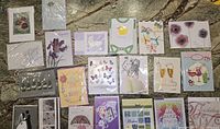 Top-down image showing a spread of assorted 3D greeting cards with floral, celebration, and sympathy themes.