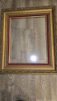 Photo of vintage ornate gold frame with red inner border, showing non-reflective glass and size fitting 15x19 inch picture