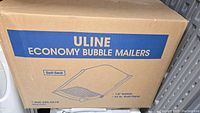 Box of Uline Economy Bubble Mailer Envelopes containing approx. 50 envelopes, showing branding and size info on box.