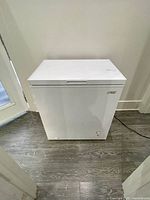 Front and side view of the white Arctic King chest freezer closed, showing compact size and minimal design.