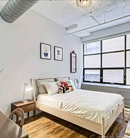 Styled and assembled bed in furnished room showing frame, slats, pillows and footboard