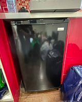 Front view of closed black Magic Chef mini fridge