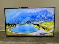 Front view of Toshiba 56-inch smart TV displaying nature scene, minor crack present but not visible in this image