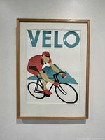 Front view of the framed print of a cyclist with text 'VELO'.