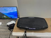 Full view of Vibrafit Slim vibration workout board showing platform surface, vibration mechanism housing, and resistance bands attached.