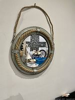Front view of the vintage nautical mirror showing the round reflective glass, thick rope frame, and hanging rope.