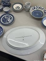 Overview of blue and white china items including teacups, dishes, and platters centered on large oval Bavaria pheasant platter underside.