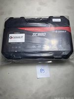 Black CGSULIT SC880 vehicle diagnostic scanner in a sealed black plastic hard case with branding and model details.